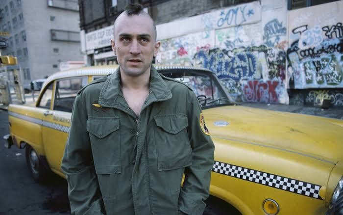 Robert De Niro beside a yellow cab in Taxi Driver